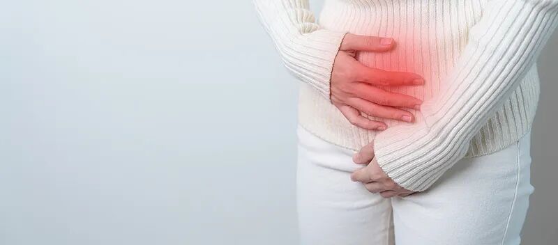 Woman holding her lower abdomen in pain